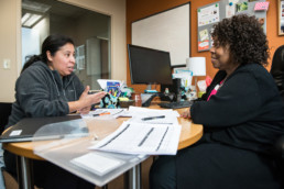 Two individuals are sitting at a table discussing financial goals